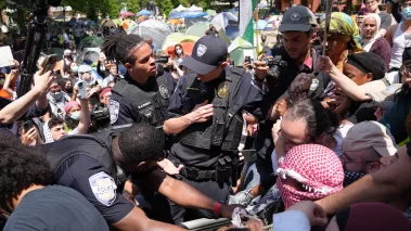 George Washington University Police officers tussle with protesters who tried to raise the Palestinian flag on the campus flagpole
